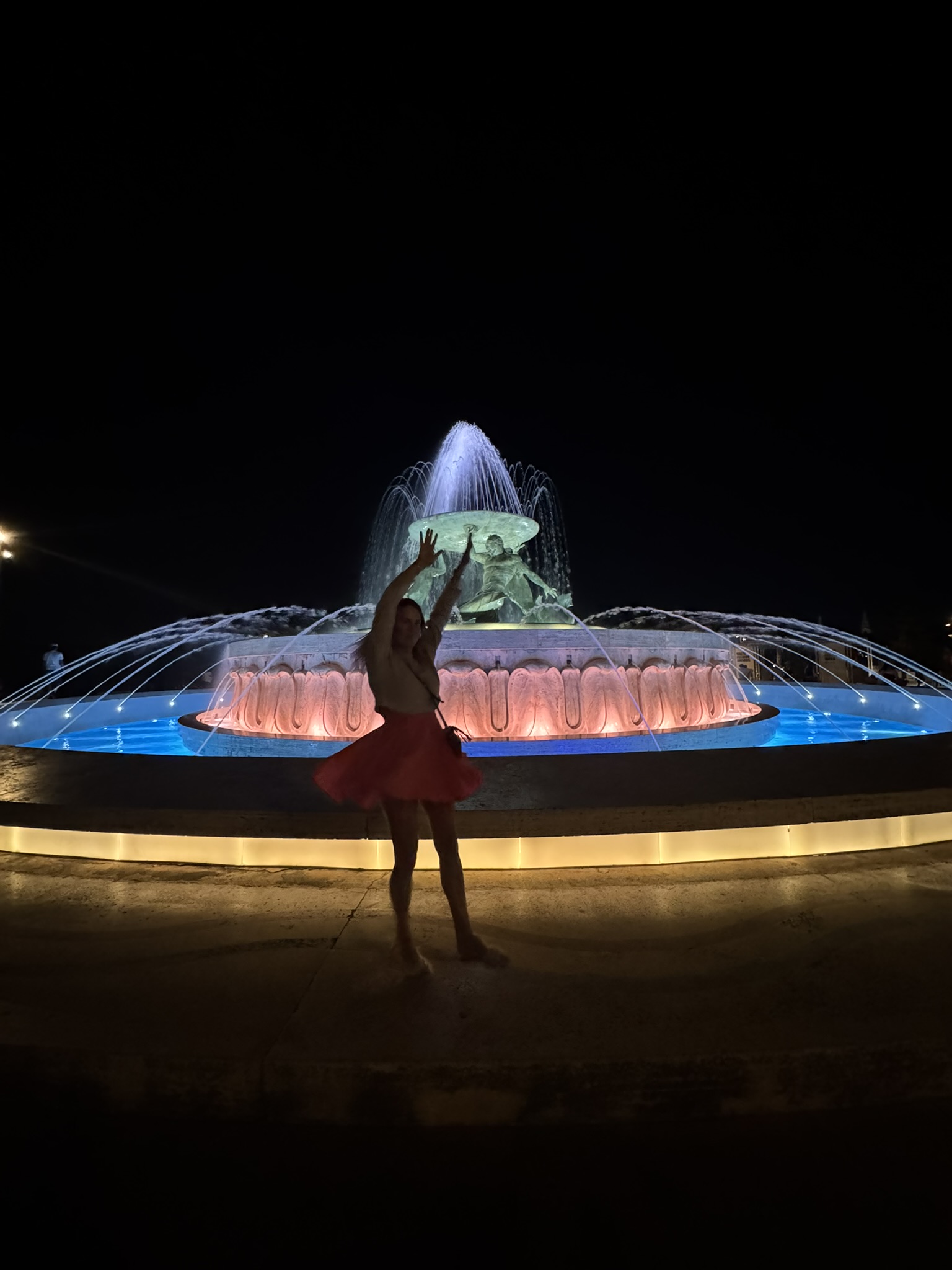 Twirling in front of a fountain at night